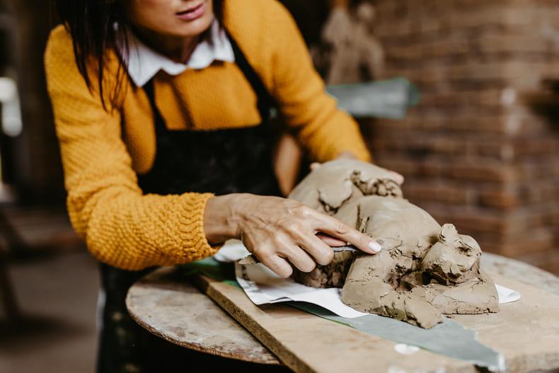 photographie d'une femme qui travaille une sculpture