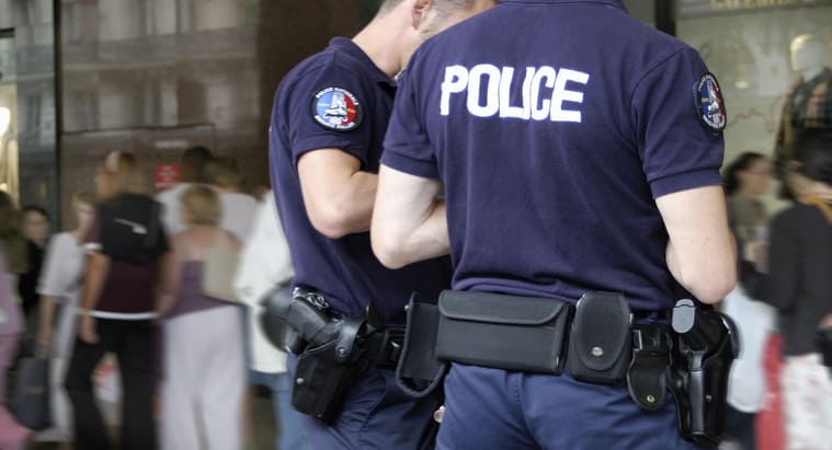 Photographie de deux policiers en uniforme et de dos 